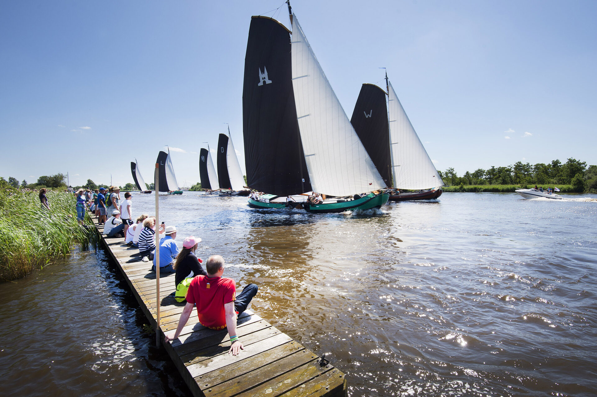 Skûtsjesilen in de Alde Feanen, publiek kijkt op de oever naar wedstrijd op het water