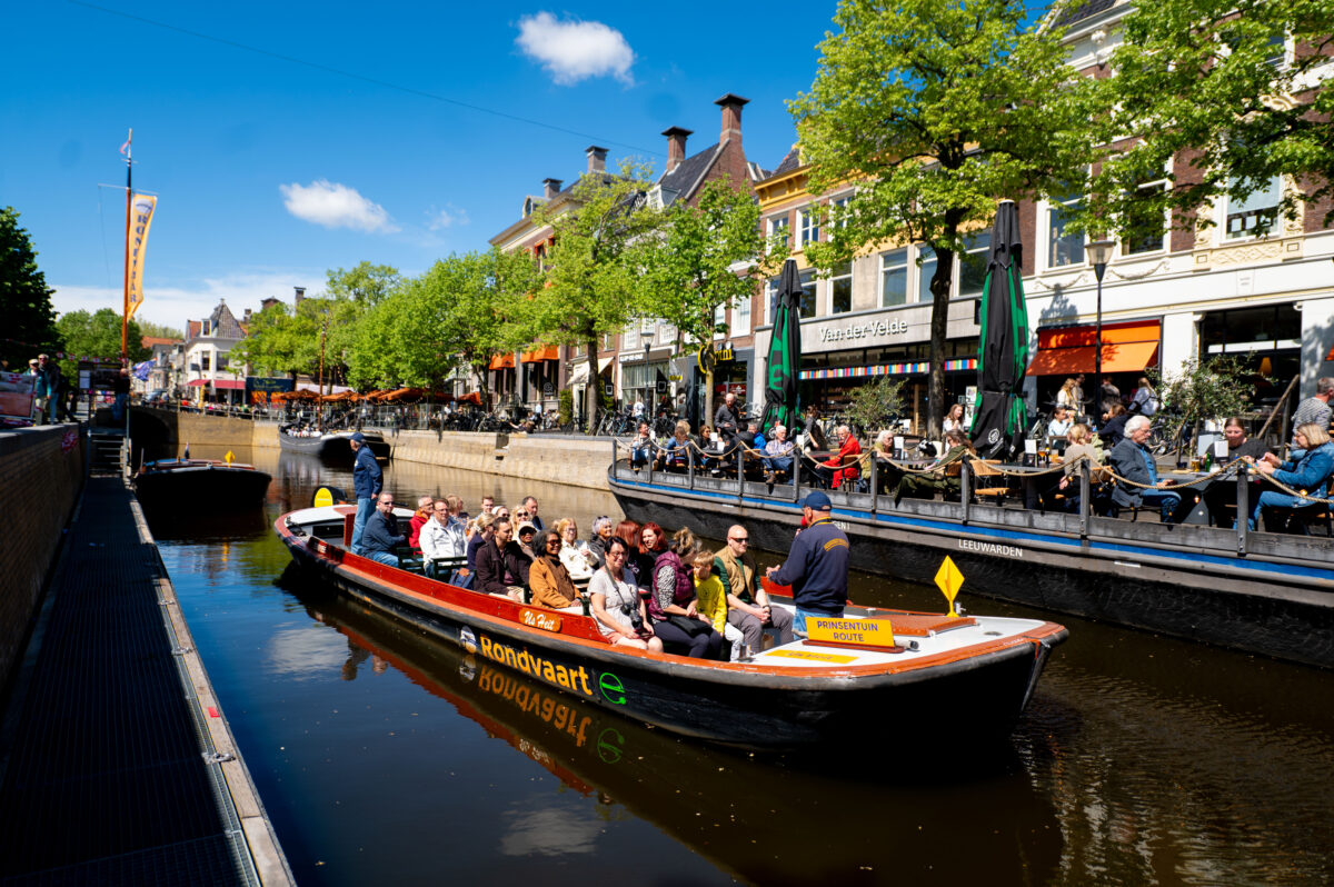 Een praam vol met toeristen in de grachten van Leeuwarden