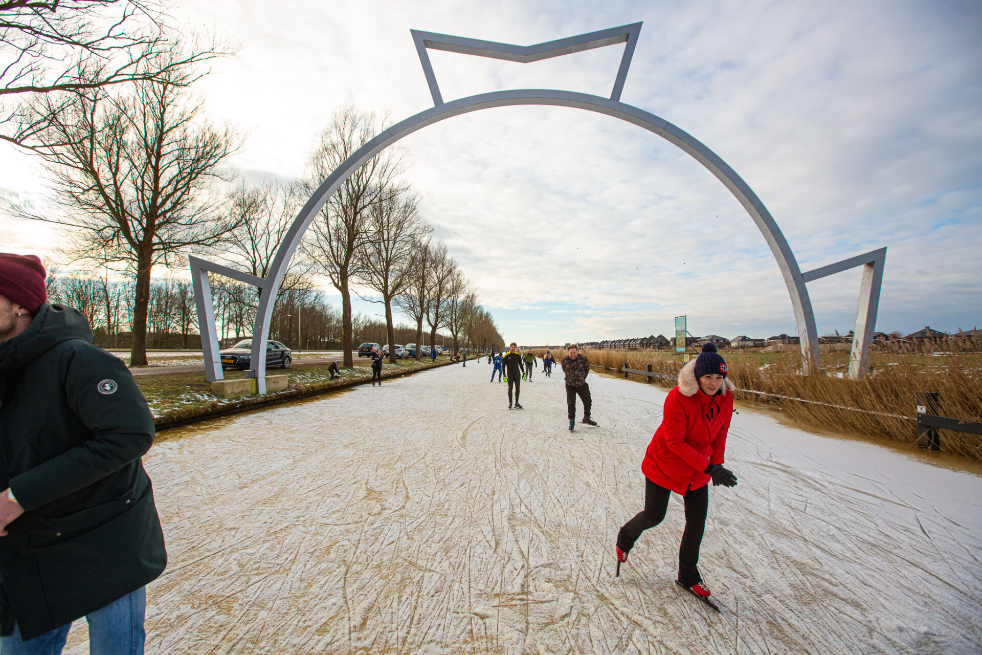 Schaatsende mensen op de Bonkevaart, onder de finish boog, winters weer. Ijs.