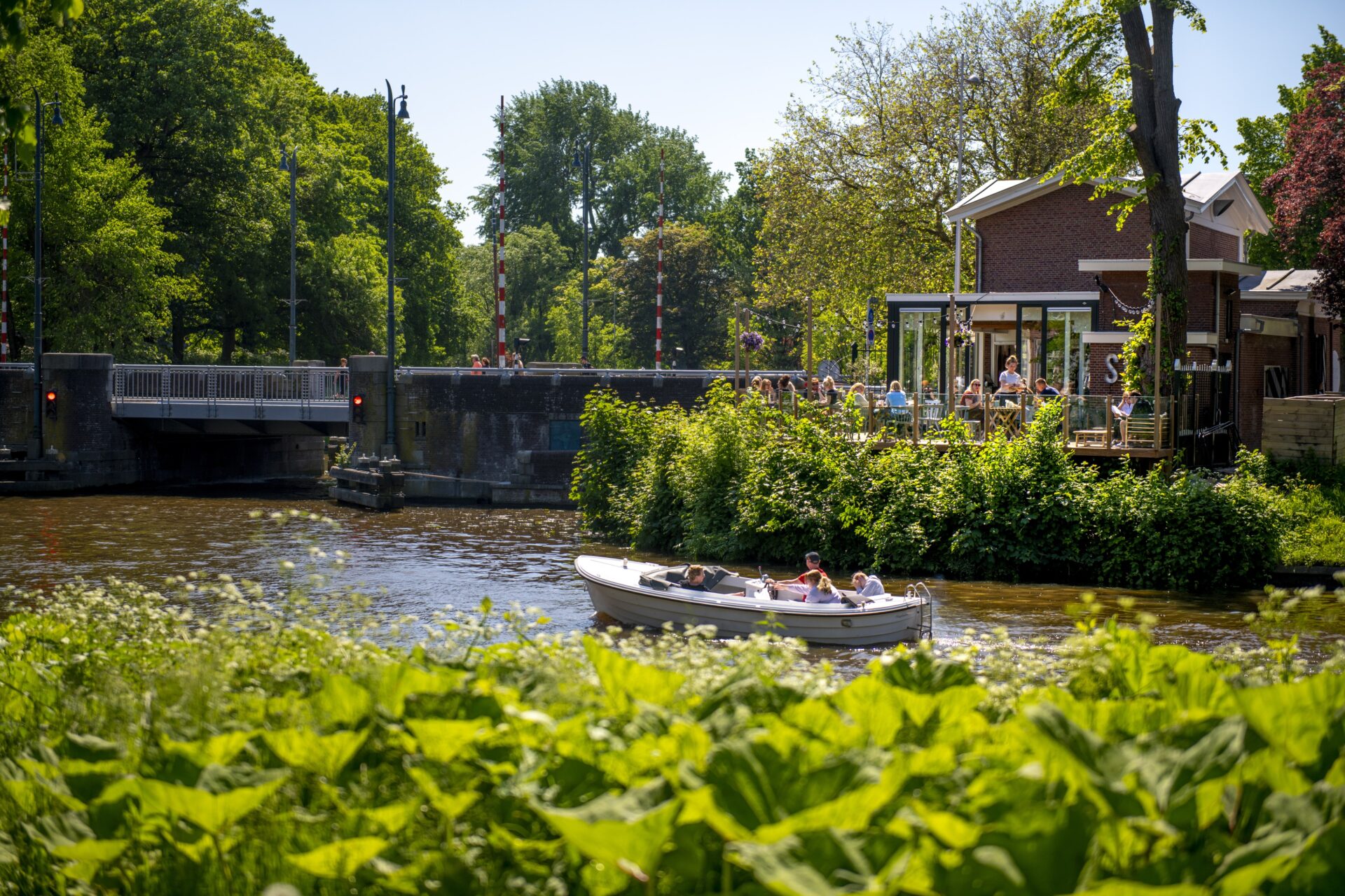 Een bootje vaart door de prinsentuin in Leeuwarden tijdens een mooie zomer dag.