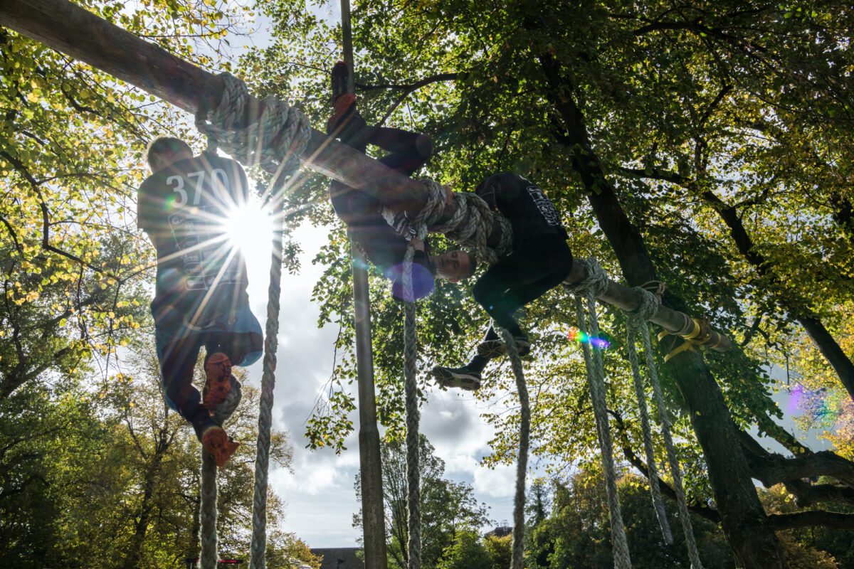 Mannen klimmen in een obstakel tijdens de survivalrun in Leeuwarden