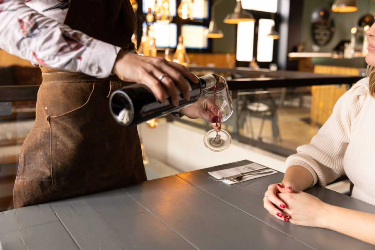 Een sommelier schenkt een glas rode wijn in in eetcafé het Leven in Leeuwarden