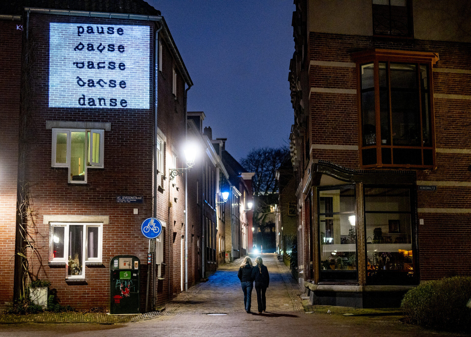 Twee mensen lopen door de binnenstad van Leeuwarden tijdens de Decemberlicht route
