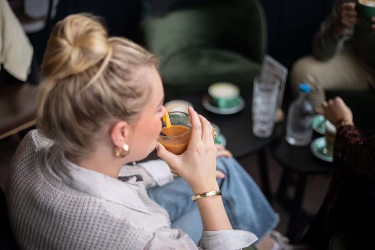 Een jonge vrouw drinkt een smoothie