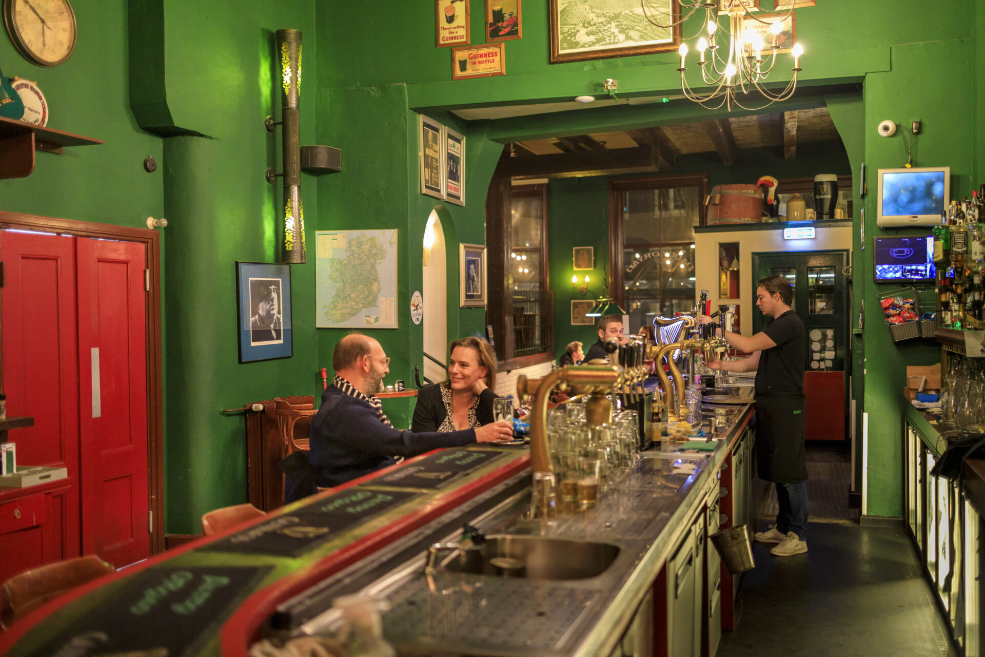 Mensen zitten aan de bar van de Ierse Pub Paddy O'Ryan in Leeuwarden en drinken een biertje