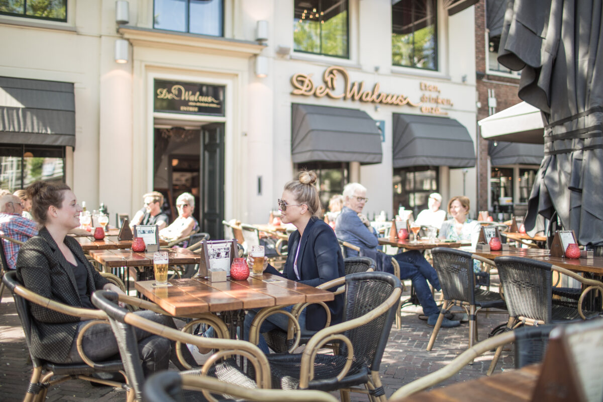 Een vol terras op een zonnige dag bij de Walrus