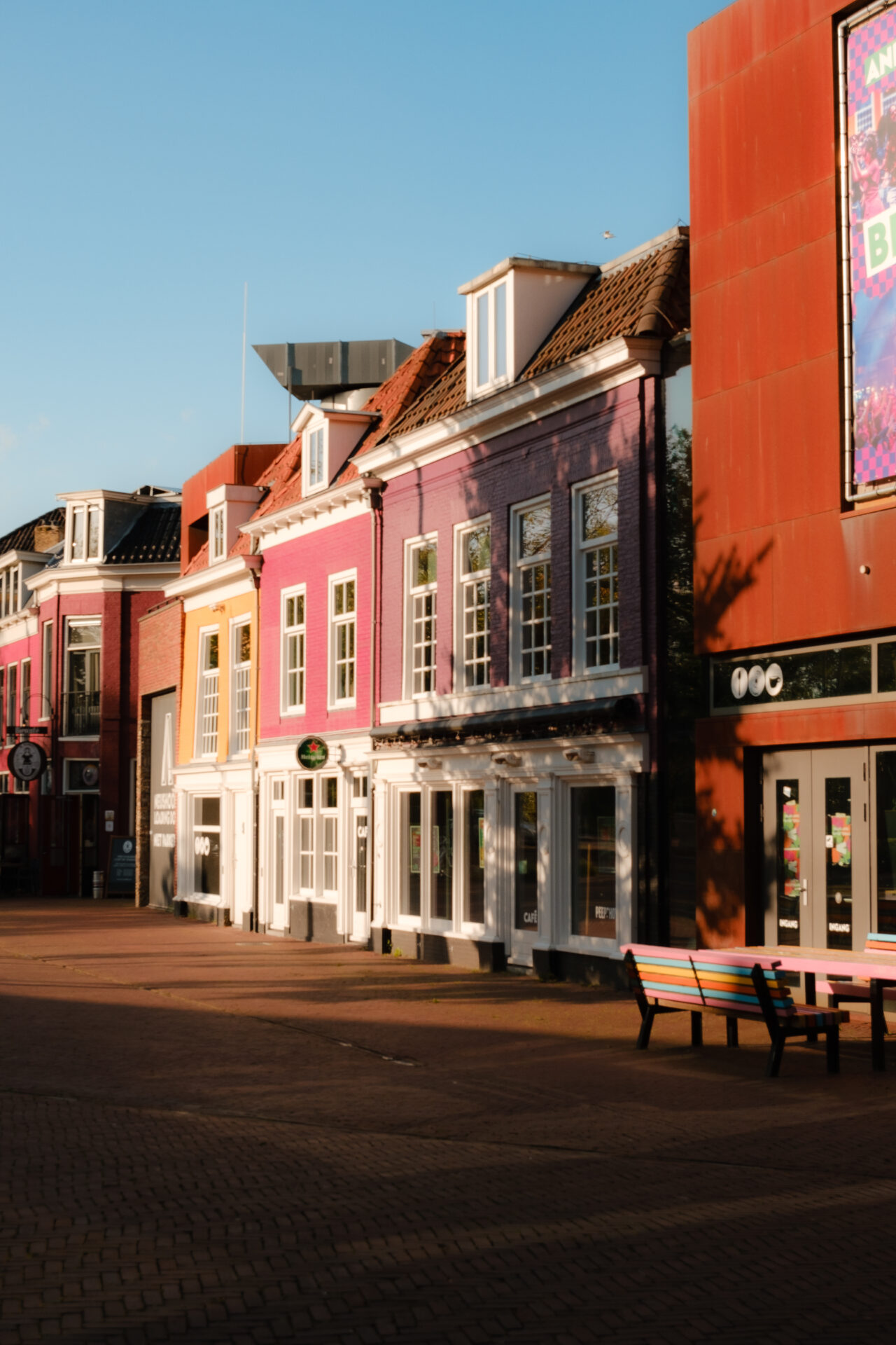 Zonsondergang bij gekleurde panden in historisch centrum.