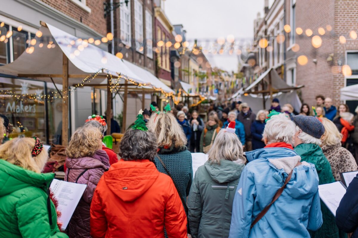 Een winterse Boerenmarkt in de Vijzelstraat met winkelende mensen bij kraampjes.