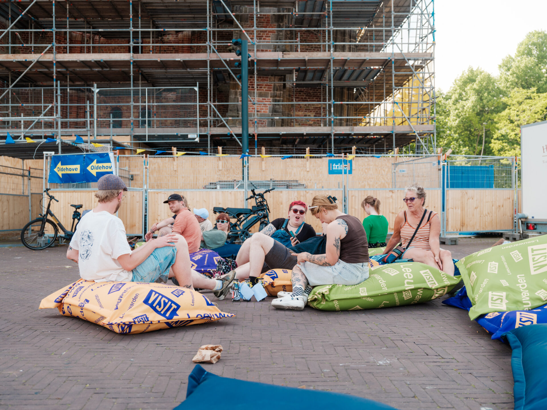 Mensen relaxen op Visit Leeuwarden zitzakken onderaan de Oldehove.