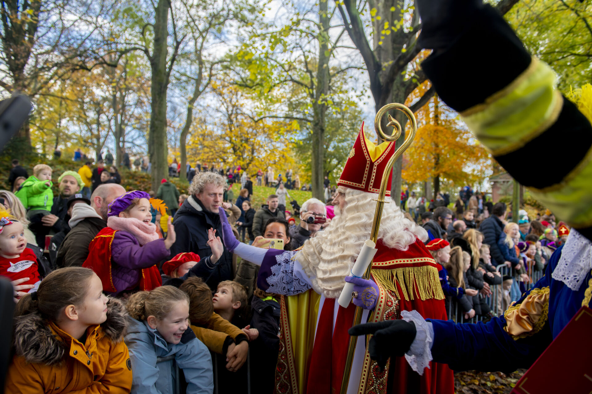 Sinterklaas zwaait naar kinderen in de prinsentuin