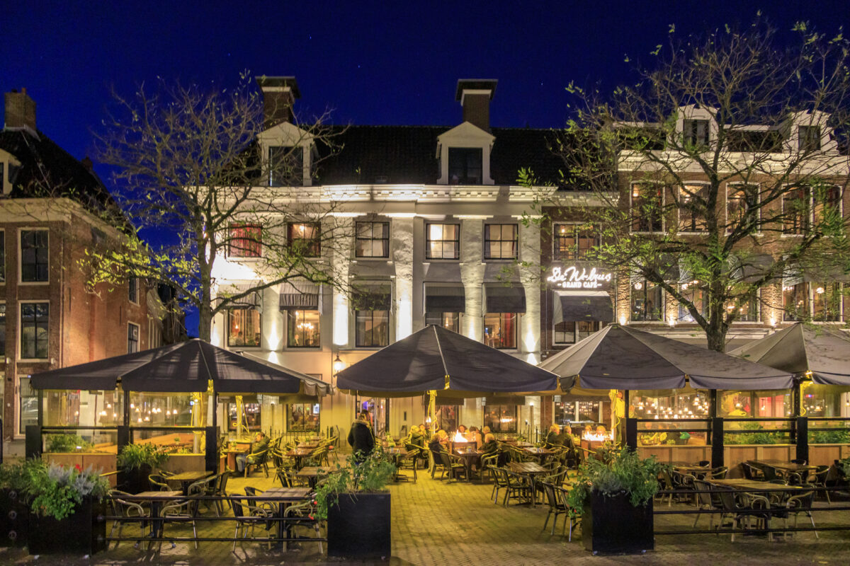 Het gezellig verlichte terras van De Walrus in de avond.