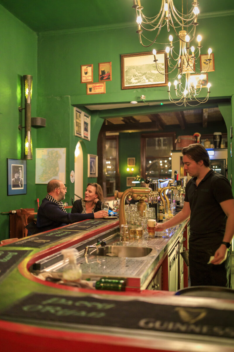 Kletsende mensen aan de bar bij Paddy O'Ryan.