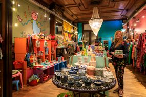 Vrouw staat met spullen in hand in de winkel NY-NA